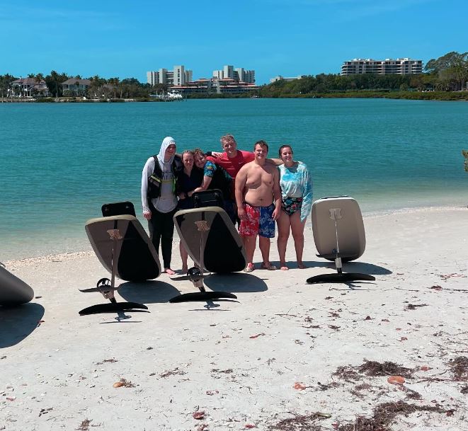 A family posing on the beach behind several eFoils