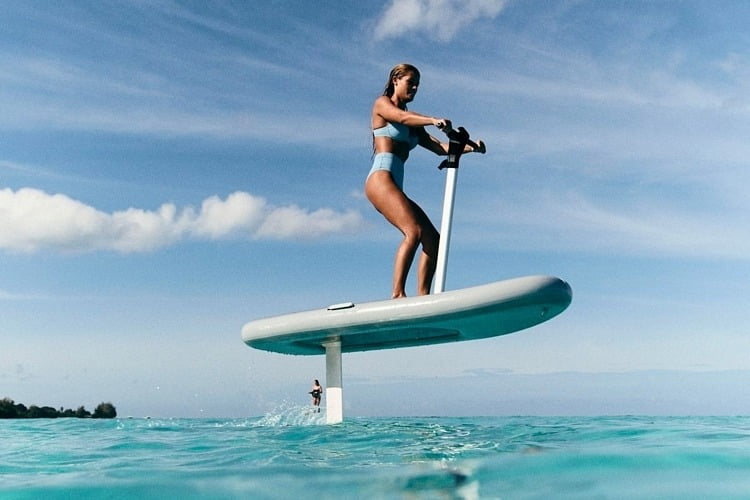 A woman gliding over Sarasota Bay on a Flitescooter